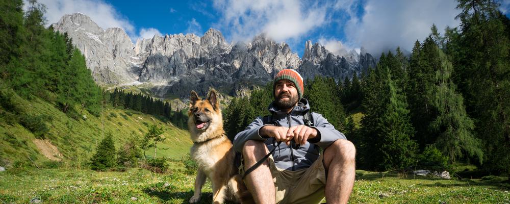 Mann mit Hund macht Wander-Pause